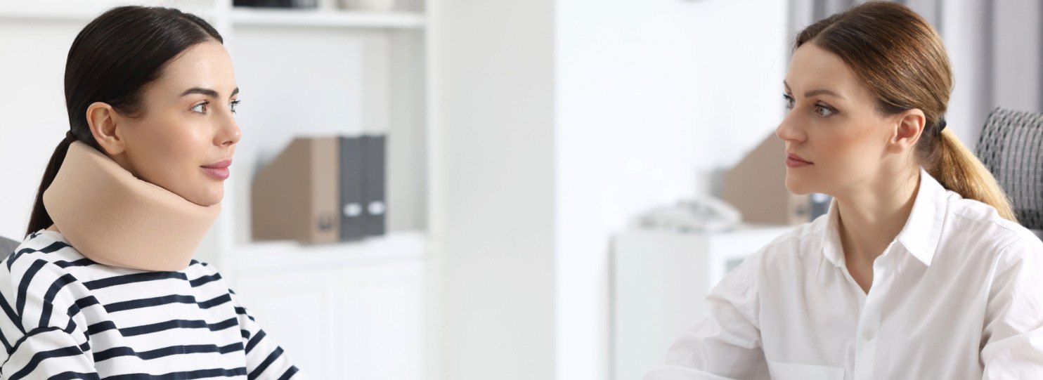 Injured client wearing a neck brace speaking with a Pinnacle Injury Law attorney