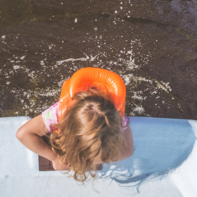 Child at a pool with a swim float requiring careful supervision