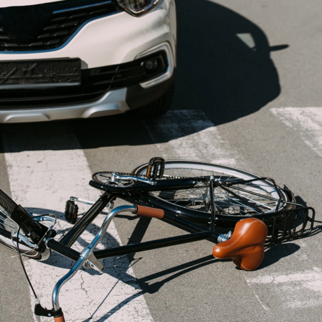 Crushed bicycle under the front bumper of a car