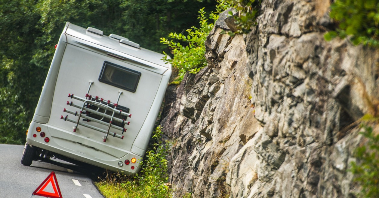 Motorhome roadside crash near a cliff with a warning triangle