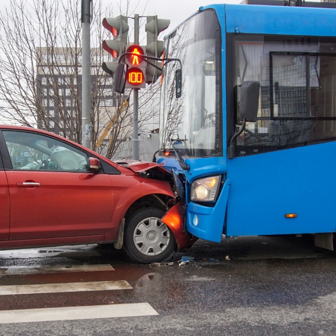 Blue bus and red car collision at an intersection