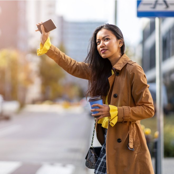 Passenger hailing a rideshare at the curb