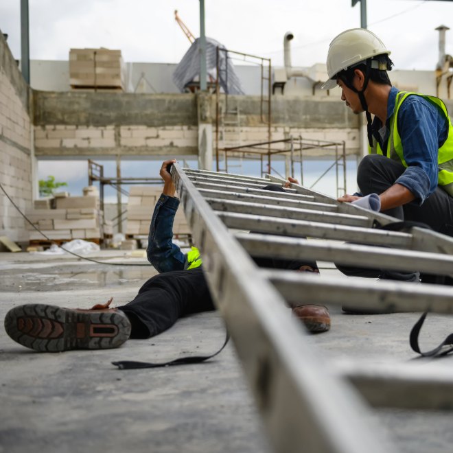 Injured construction worker near site materials and rebar